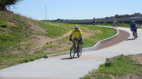 four bike riders on new concrete trail
