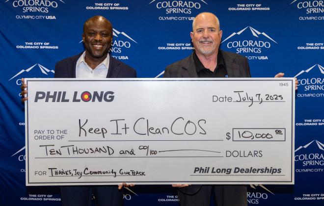 Mayor Yemi (left) and Kevin Shaughnessy (right) pose behind a giant check for $10,000 made out to Keep It Clean COS.