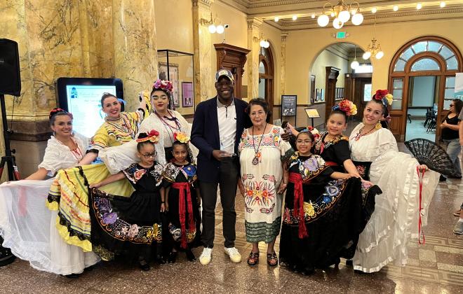 Mayor Yemi stands with community members and Connie Benavidez as he presents her with the Spirit of Colorado Springs Award