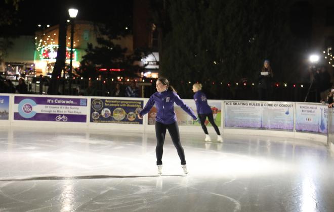 Two Team USA Figure Skating athletes skate on the ice rink in Acacia Park on the opening night celebrating in 2024.